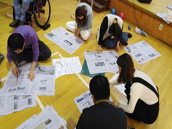  명랑운동회 진행 중(팀빌딩게임에서 나온 내용을 신문에 나온 글씨를 찾아 내용에 맞게 붙이는 게임)    